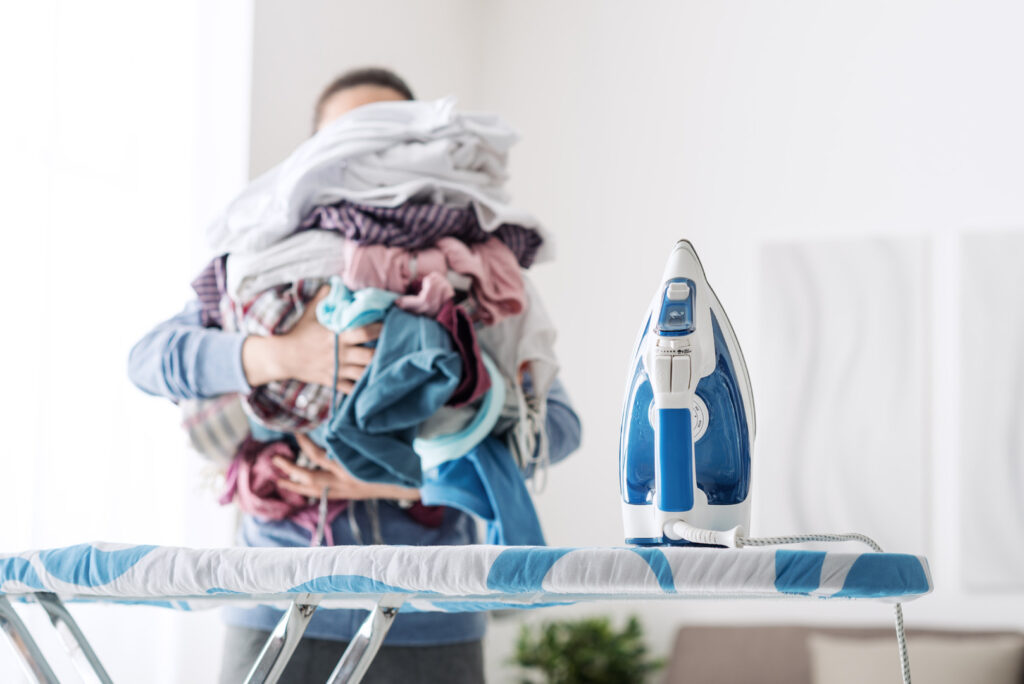 Hausfrau,bringt,einen,riesigen,Stapel,Wäsche,auf,das,Bügeln